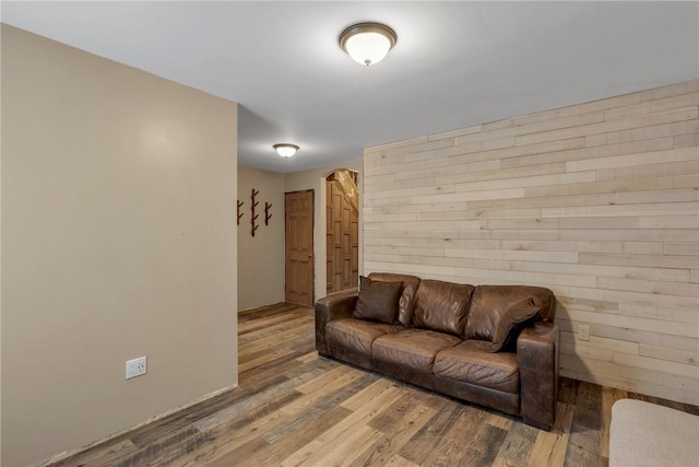 living room with wood walls and wood-type flooring