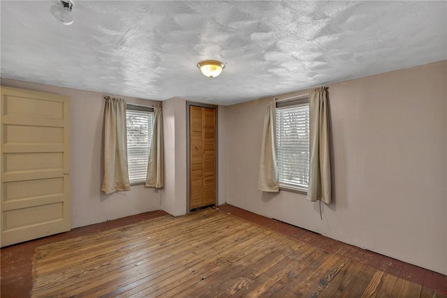 spare room with hardwood / wood-style floors and a textured ceiling