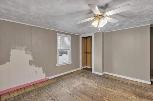 unfurnished room featuring hardwood / wood-style flooring, ceiling fan, and crown molding