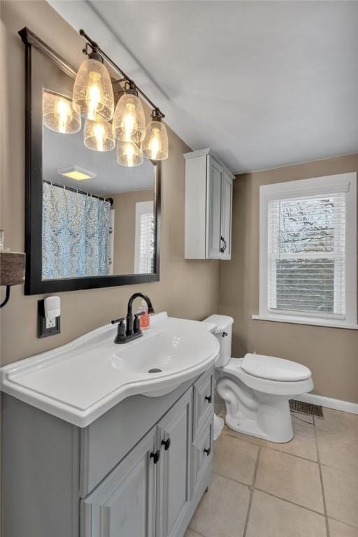 bathroom with tile patterned flooring, vanity, and toilet