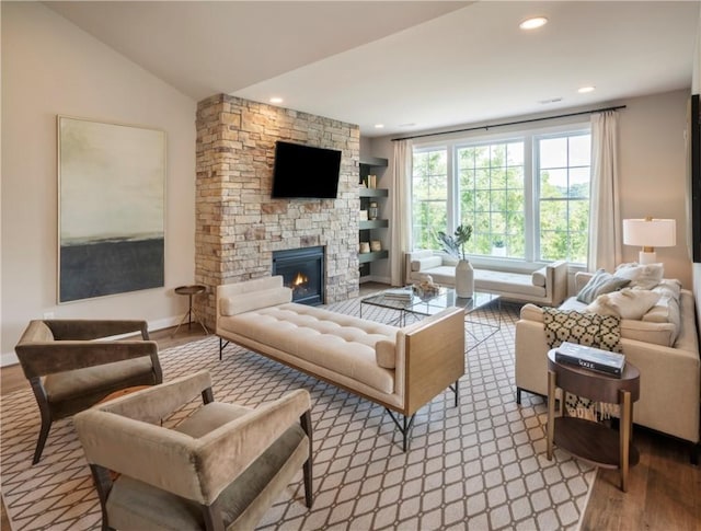 living room with a fireplace, light wood-type flooring, and vaulted ceiling