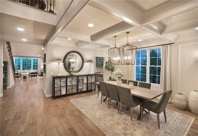 dining space with an inviting chandelier, beamed ceiling, coffered ceiling, and hardwood / wood-style flooring