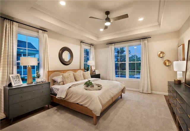 carpeted bedroom with ceiling fan, a raised ceiling, and crown molding