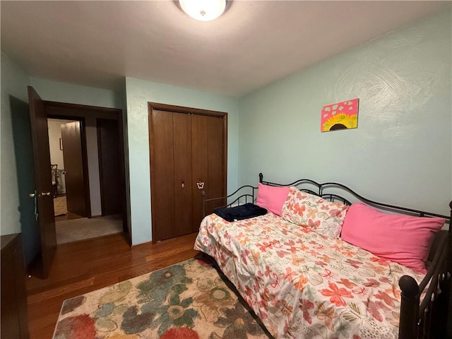 bedroom with dark hardwood / wood-style flooring and a closet