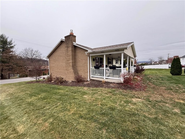 view of side of property featuring a porch and a yard