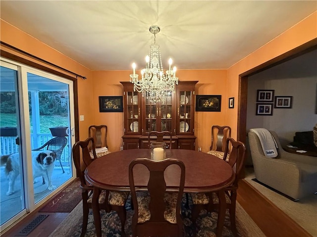 dining room with dark hardwood / wood-style flooring and a chandelier