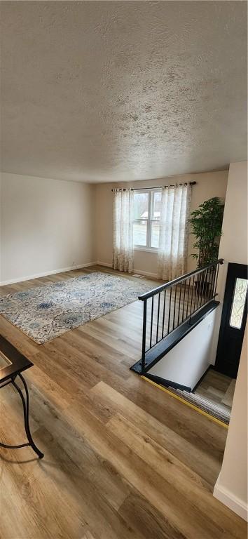 interior space with wood-type flooring and a textured ceiling