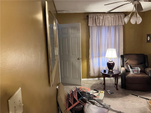 sitting room featuring carpet and ceiling fan