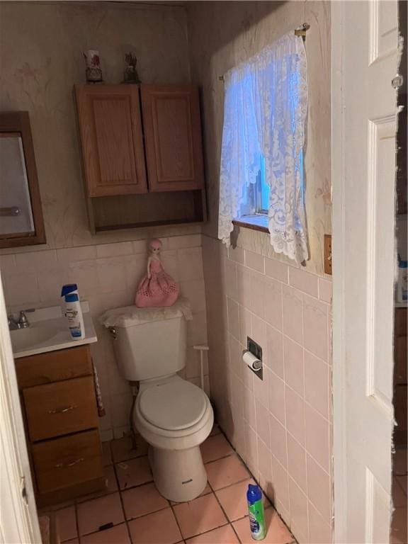 bathroom with tile patterned flooring, vanity, toilet, and tile walls