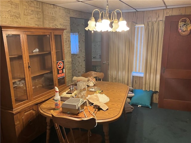 dining space with a paneled ceiling and a chandelier