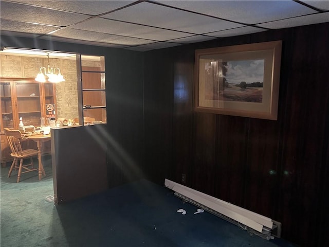 interior space with carpet flooring, a paneled ceiling, and an inviting chandelier