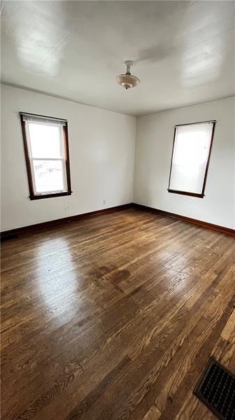 unfurnished room with dark hardwood / wood-style floors