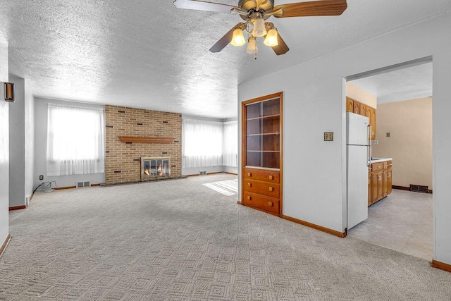 unfurnished living room with plenty of natural light, ceiling fan, and light carpet