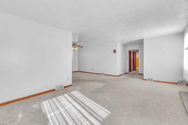 carpeted empty room with ceiling fan and a textured ceiling