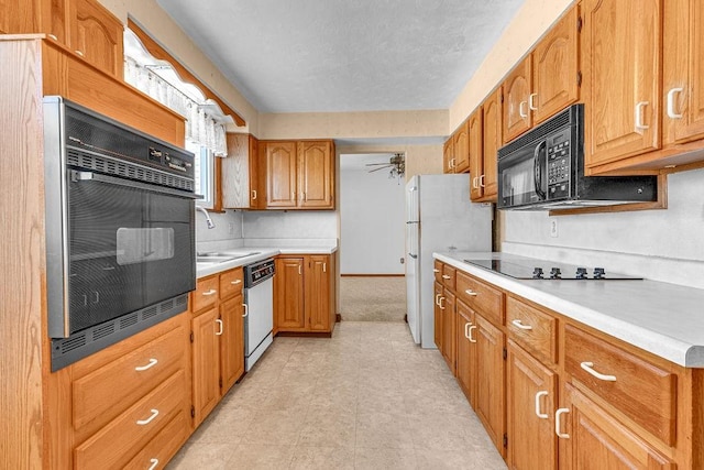 kitchen featuring black appliances, ceiling fan, and sink