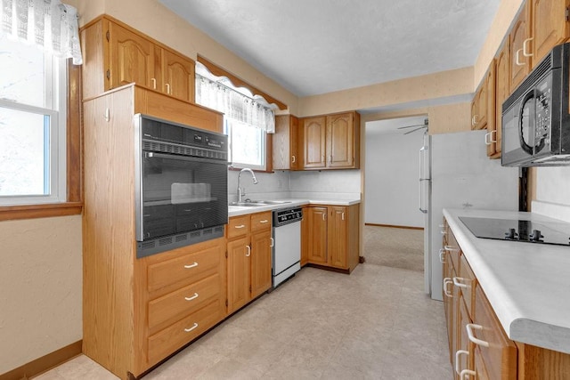 kitchen with black appliances, ceiling fan, and sink