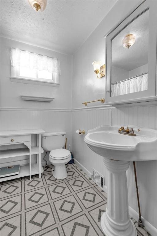 bathroom featuring toilet and a textured ceiling