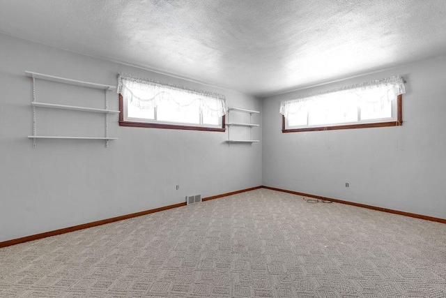 carpeted spare room with a textured ceiling