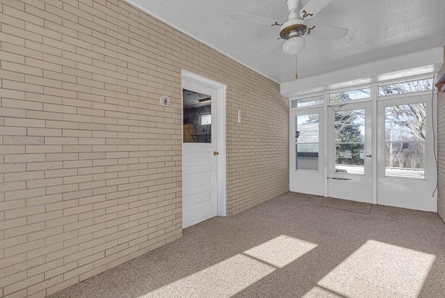 unfurnished sunroom with ceiling fan