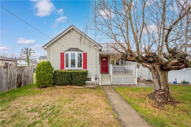 bungalow with covered porch and a front lawn