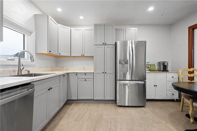 kitchen with gray cabinets, sink, and stainless steel appliances