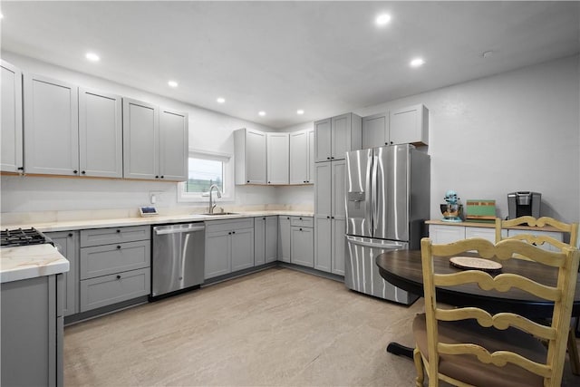 kitchen featuring gray cabinetry, sink, and appliances with stainless steel finishes