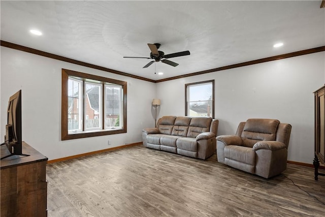 living room with hardwood / wood-style flooring, a wealth of natural light, ornamental molding, and ceiling fan