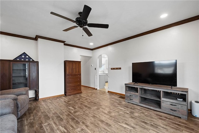 living room featuring ceiling fan, crown molding, wood-type flooring, and sink