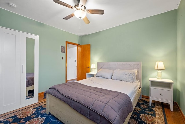 bedroom with ceiling fan, a closet, and dark hardwood / wood-style floors