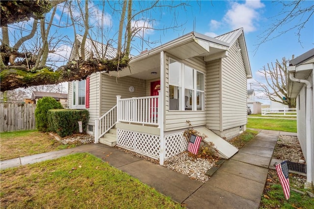 view of front of house featuring covered porch and a front lawn