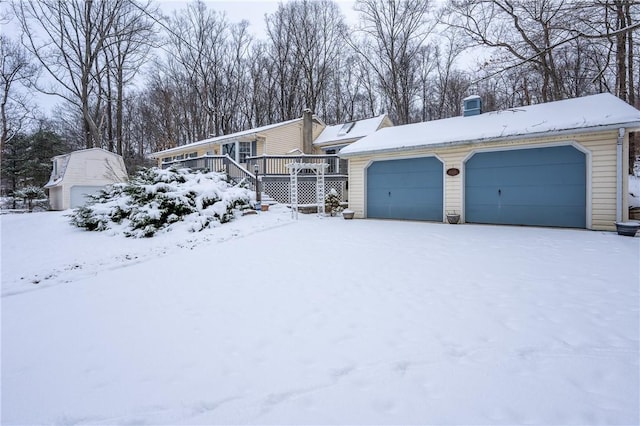 view of front of house with a garage, an outbuilding, and a wooden deck