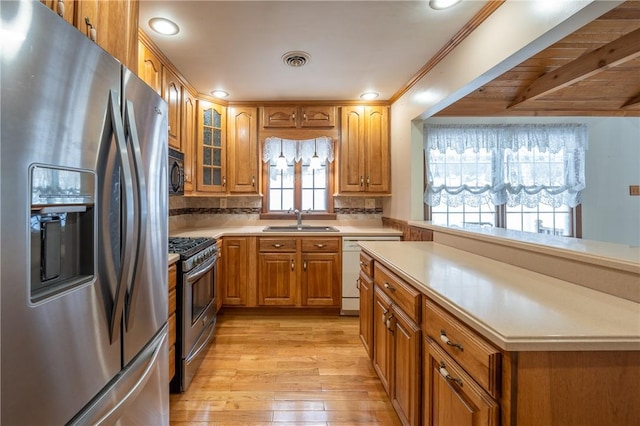 kitchen with decorative backsplash, stainless steel appliances, crown molding, sink, and light hardwood / wood-style floors