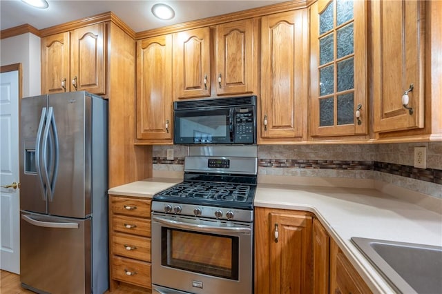 kitchen featuring decorative backsplash, stainless steel appliances, crown molding, and sink