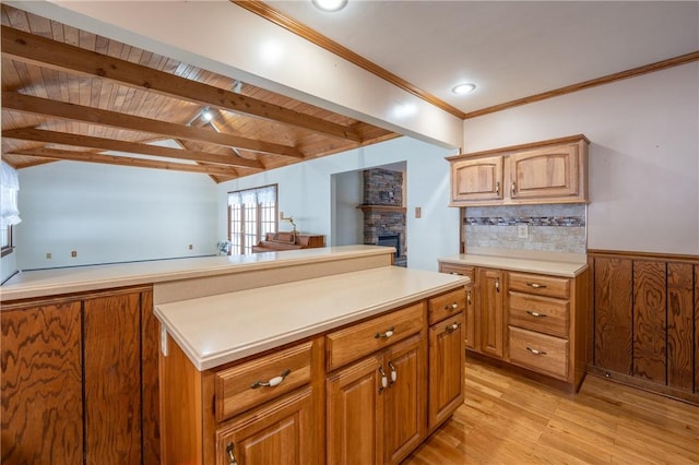 kitchen with a stone fireplace, beamed ceiling, backsplash, wood ceiling, and light wood-type flooring