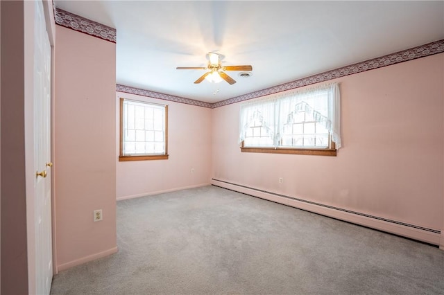 empty room featuring light colored carpet, baseboard heating, and ceiling fan