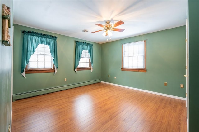 spare room with ceiling fan, light hardwood / wood-style floors, and a baseboard heating unit