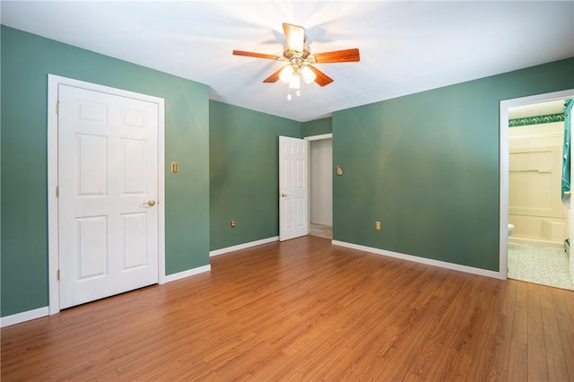 unfurnished bedroom with connected bathroom, ceiling fan, and wood-type flooring