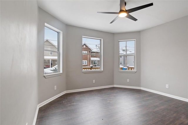 empty room with plenty of natural light, ceiling fan, and dark hardwood / wood-style floors