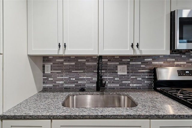 kitchen featuring backsplash, white cabinetry, and stainless steel appliances