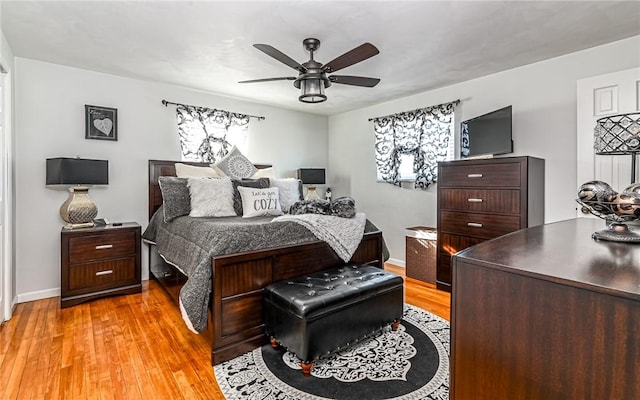 bedroom with multiple windows, light hardwood / wood-style floors, and ceiling fan