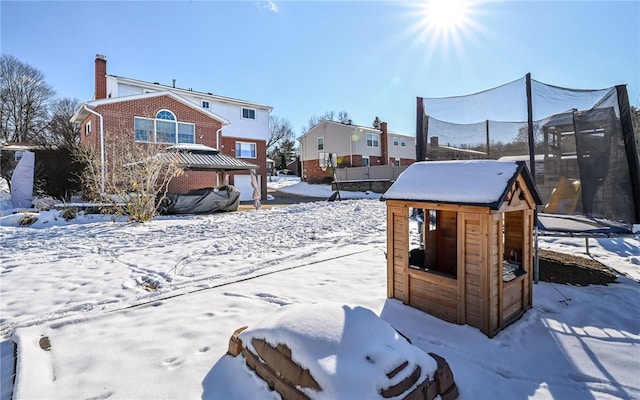 snowy yard with a gazebo and a trampoline