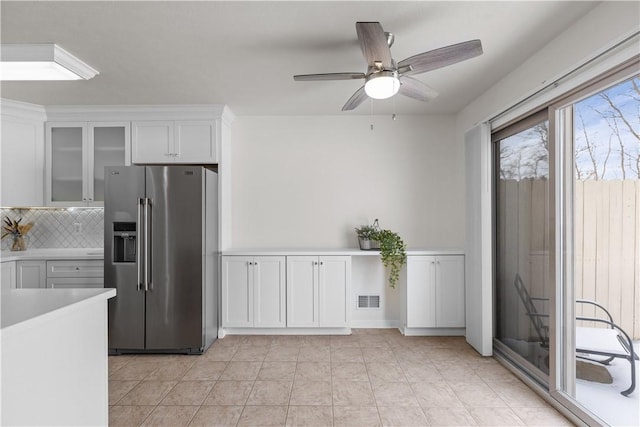 kitchen with white cabinets, ceiling fan, high end fridge, and backsplash