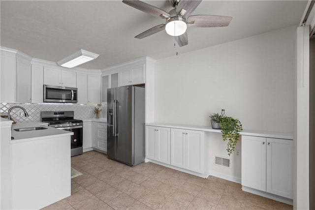 kitchen featuring appliances with stainless steel finishes, backsplash, white cabinetry, and sink