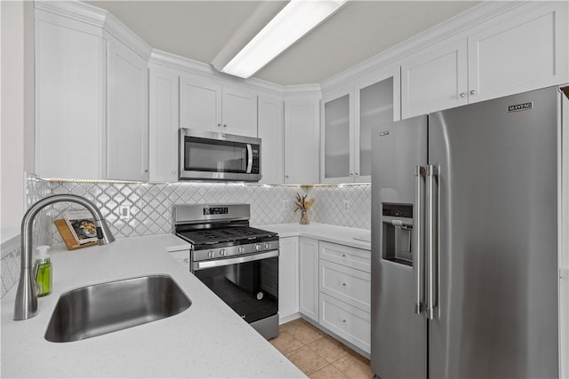 kitchen with tasteful backsplash, white cabinetry, sink, and stainless steel appliances