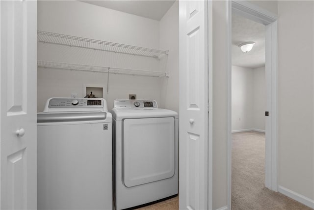 clothes washing area with washer and dryer and light colored carpet