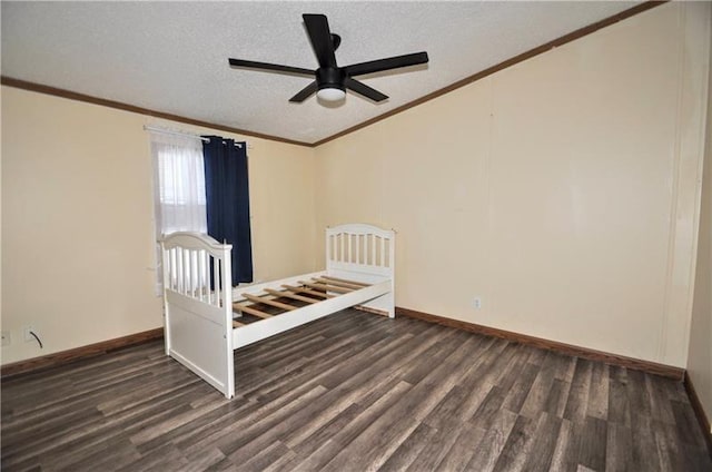 unfurnished bedroom with dark hardwood / wood-style flooring, a textured ceiling, ceiling fan, and crown molding