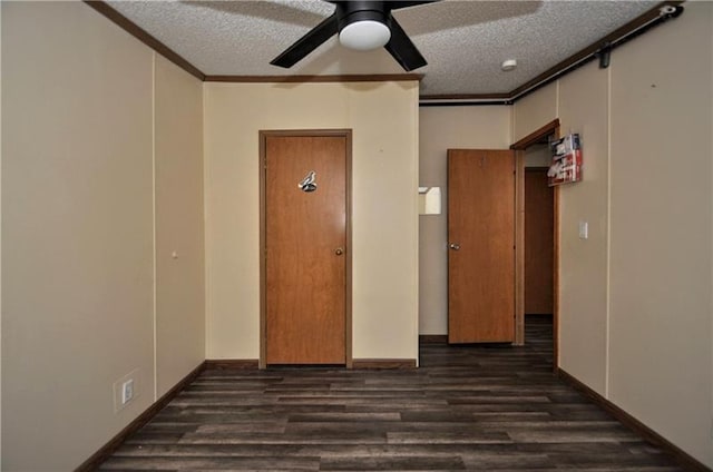 empty room featuring ceiling fan, crown molding, dark hardwood / wood-style floors, and a textured ceiling