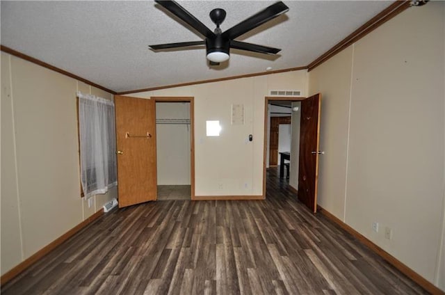 unfurnished bedroom featuring ceiling fan, dark hardwood / wood-style flooring, a textured ceiling, vaulted ceiling, and ornamental molding