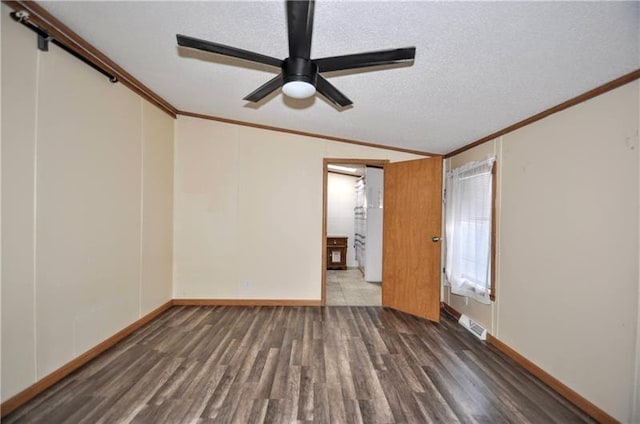 spare room featuring ceiling fan, dark hardwood / wood-style flooring, vaulted ceiling, a textured ceiling, and ornamental molding