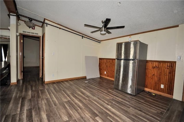 interior space featuring wood walls, crown molding, ceiling fan, dark hardwood / wood-style floors, and a textured ceiling